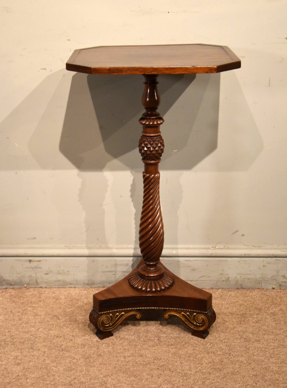 A Regency mahogany occasional table featuring an octagonal top, a carved spiral stem, and a tri-form pedestal base with scroll feet. View III