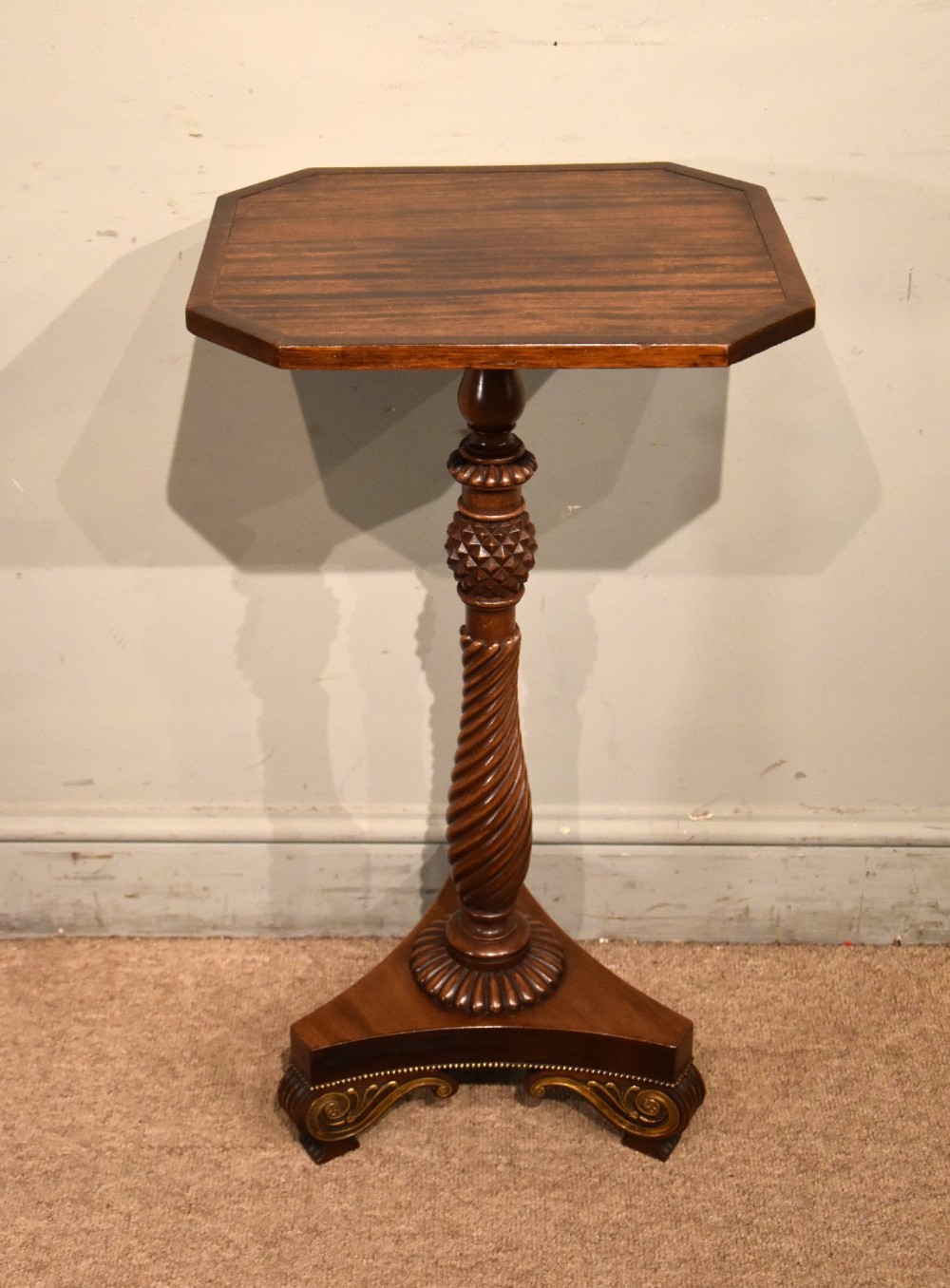 A Regency mahogany occasional table featuring an octagonal top, a carved spiral stem, and a tri-form pedestal base with scroll feet. View IV