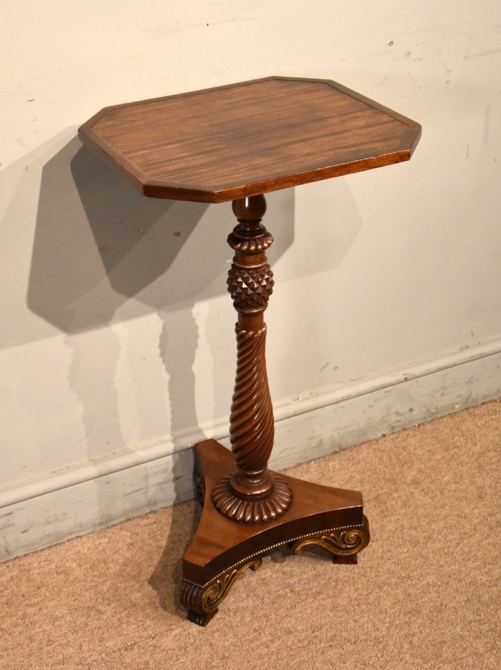 A Regency mahogany occasional table featuring an octagonal top, a carved spiral stem, and a tri-form pedestal base with scroll feet. View V