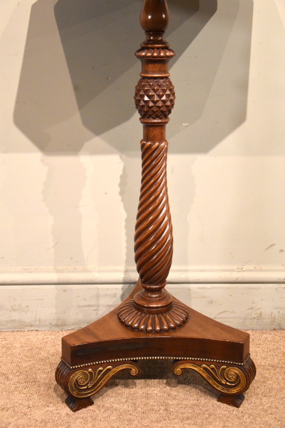A Regency mahogany occasional table featuring an octagonal top, a carved spiral stem, and a tri-form pedestal base with scroll feet. View VI