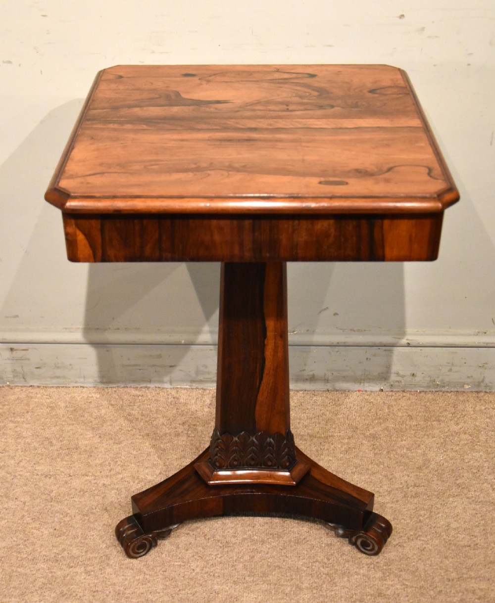 A William IV rosewood side table with a square top, plain frieze, tapered central pedestal, and a tri-form platform base on scroll feet. View III