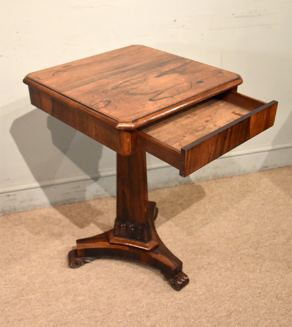 A William IV rosewood side table with a square top, plain frieze, tapered central pedestal, and a tri-form platform base on scroll feet. View VI