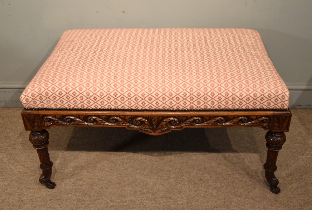 A Victorian rectangular rosewood dressing stool with patterned pink fabric upholstery, studding details, an acanthus-carved apron, and turned legs. View II