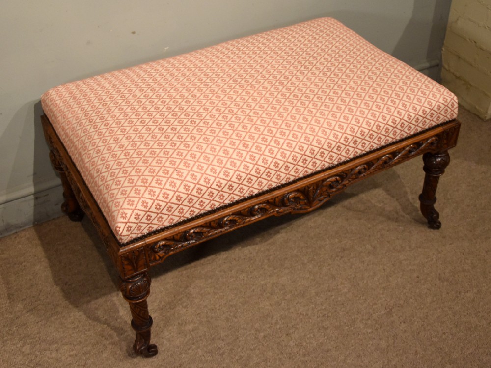A Victorian rectangular rosewood dressing stool with patterned pink fabric upholstery, studding details, an acanthus-carved apron, and turned legs. View III