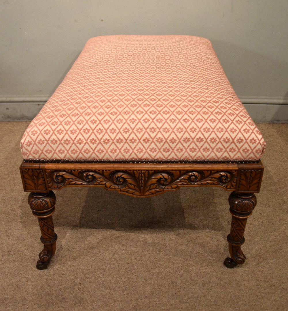 A Victorian rectangular rosewood dressing stool with patterned pink fabric upholstery, studding details, an acanthus-carved apron, and turned legs. View IV