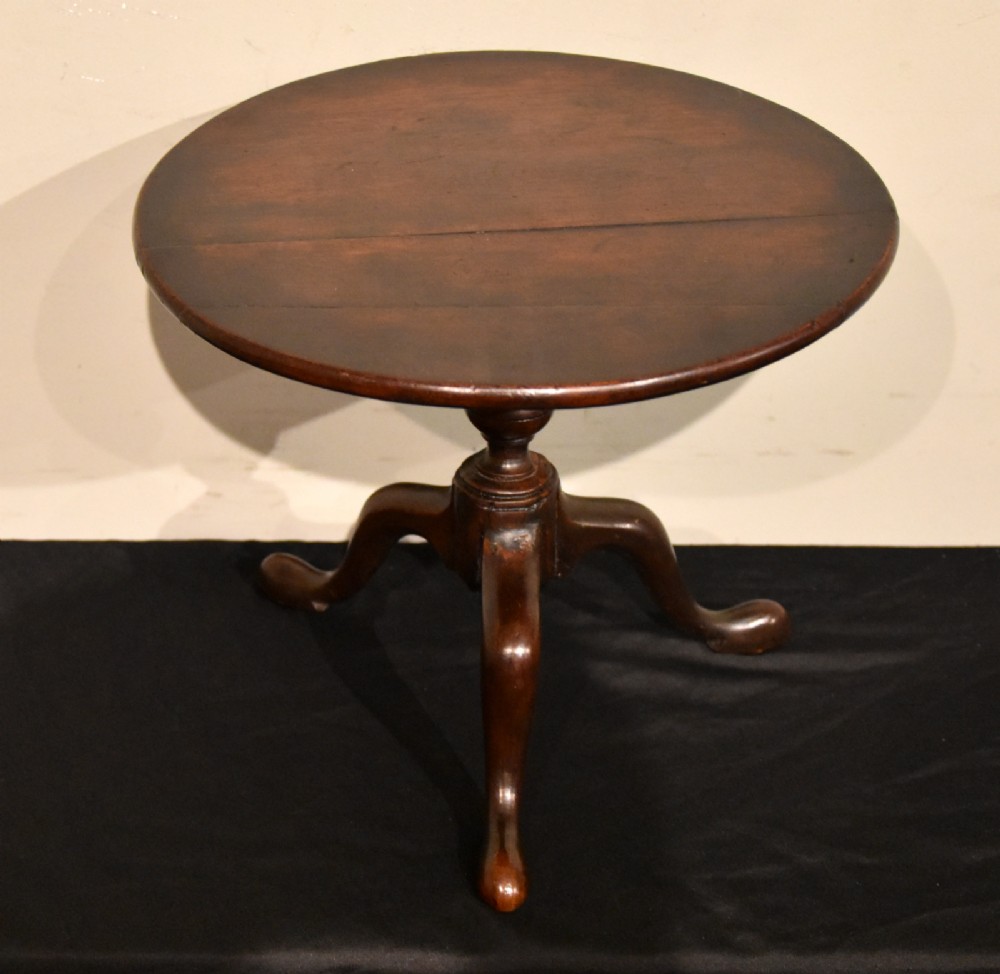 A George III miniature mahogany tripod table with a circular top, turned central column, and cabriole legs terminating in pad feet.
