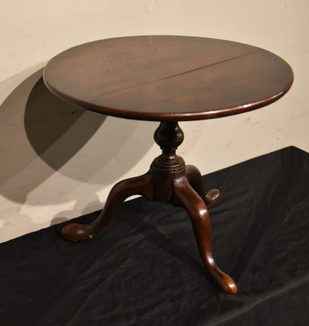 A George III miniature mahogany tripod table with a circular top, turned central column, and cabriole legs terminating in pad feet. View II