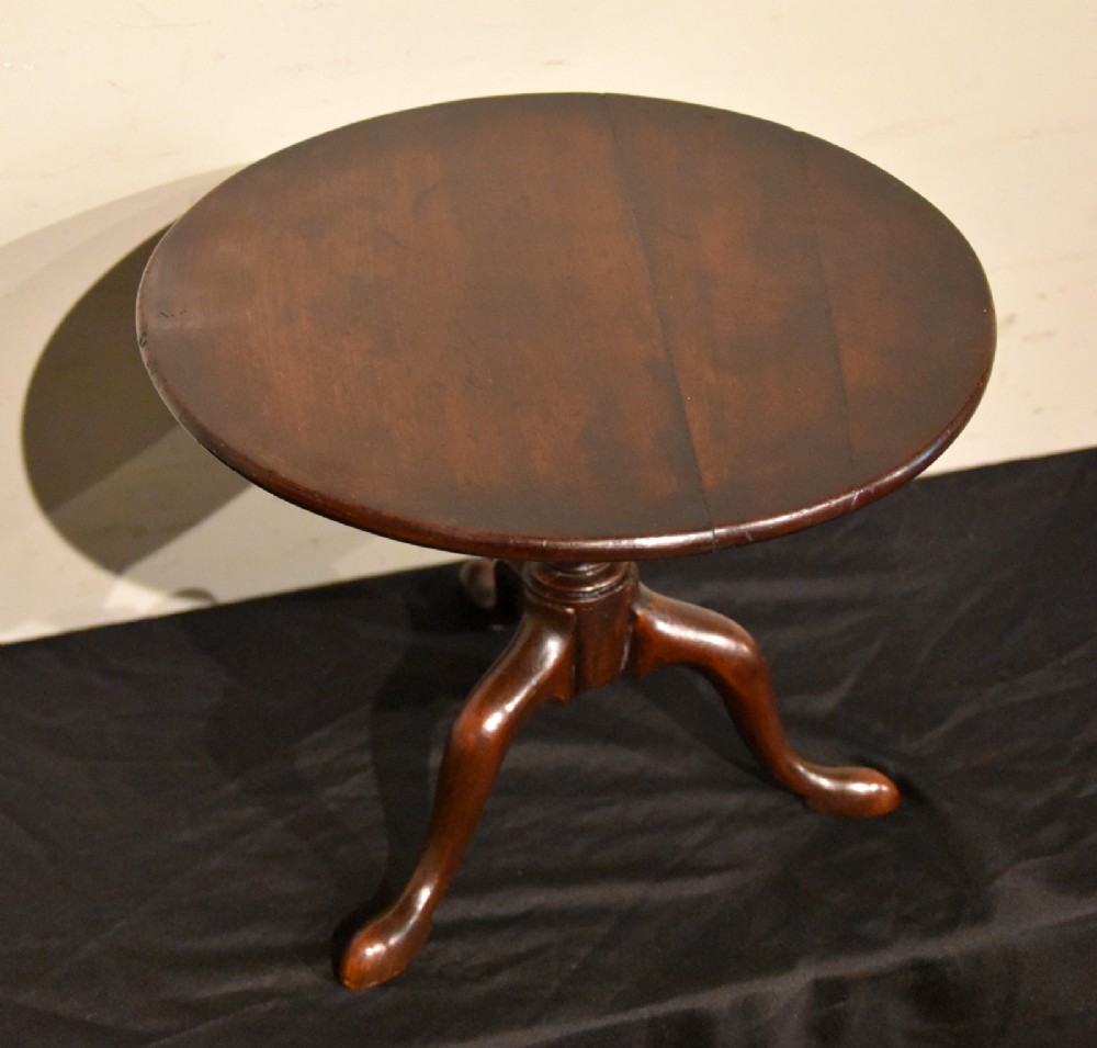 A George III miniature mahogany tripod table with a circular top, turned central column, and cabriole legs terminating in pad feet. View III
