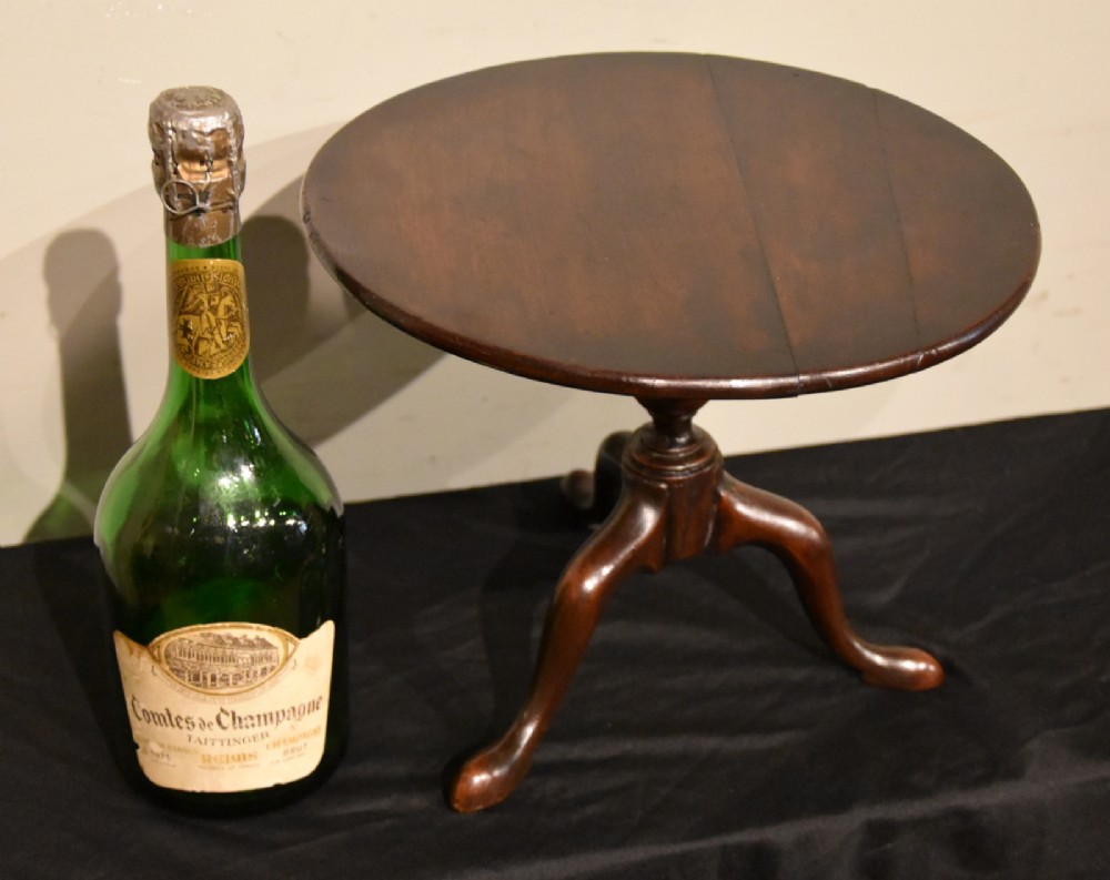 A George III miniature mahogany tripod table with a circular top, turned central column, and cabriole legs terminating in pad feet. View IV