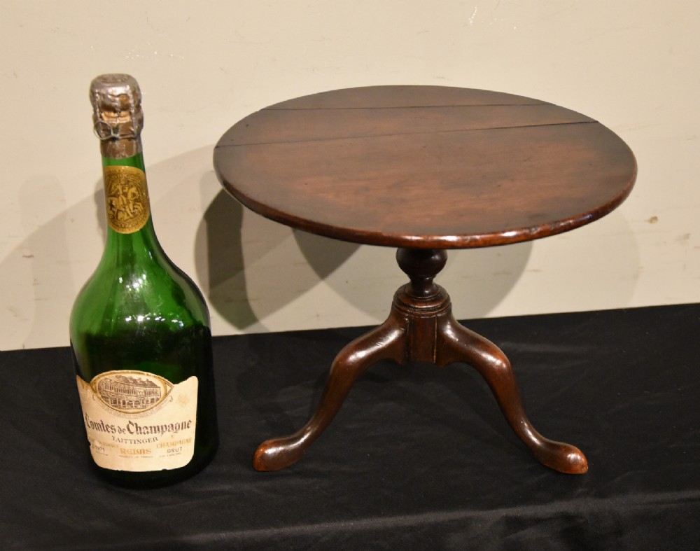 A George III miniature mahogany tripod table with a circular top, turned central column, and cabriole legs terminating in pad feet. View V