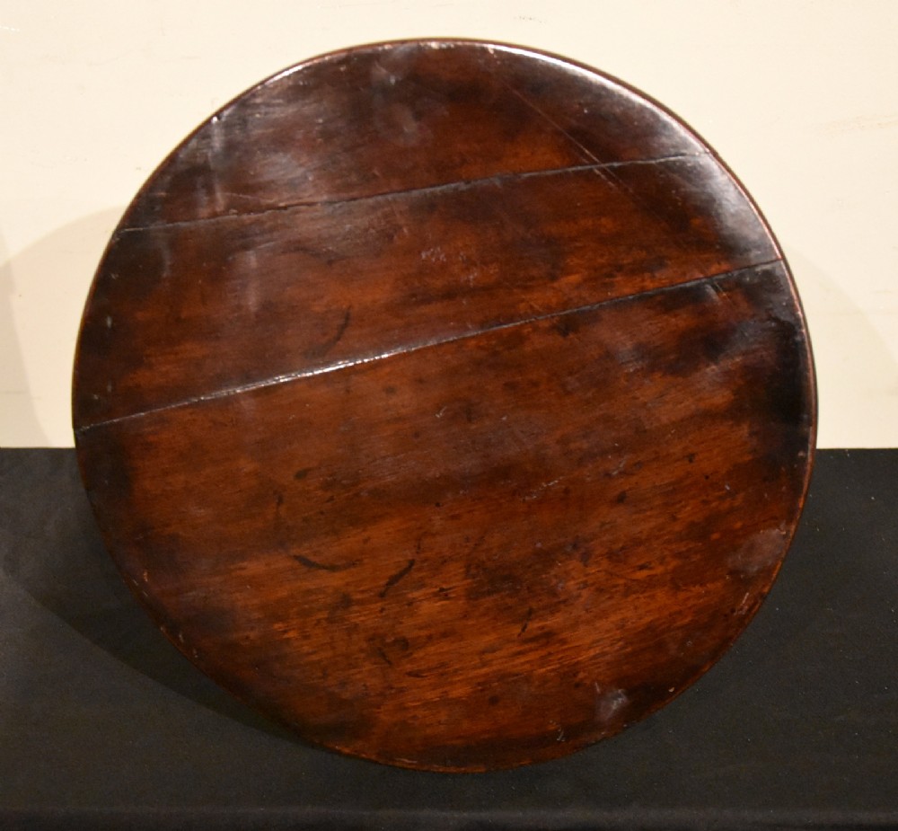 A George III miniature mahogany tripod table with a circular top, turned central column, and cabriole legs terminating in pad feet. View VI
