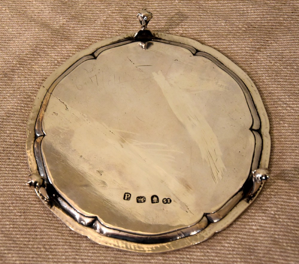 A circular Georgian sterling silver waiter featuring a beaded rim, central engraved monogram, and cast claw-and-ball feet. View III