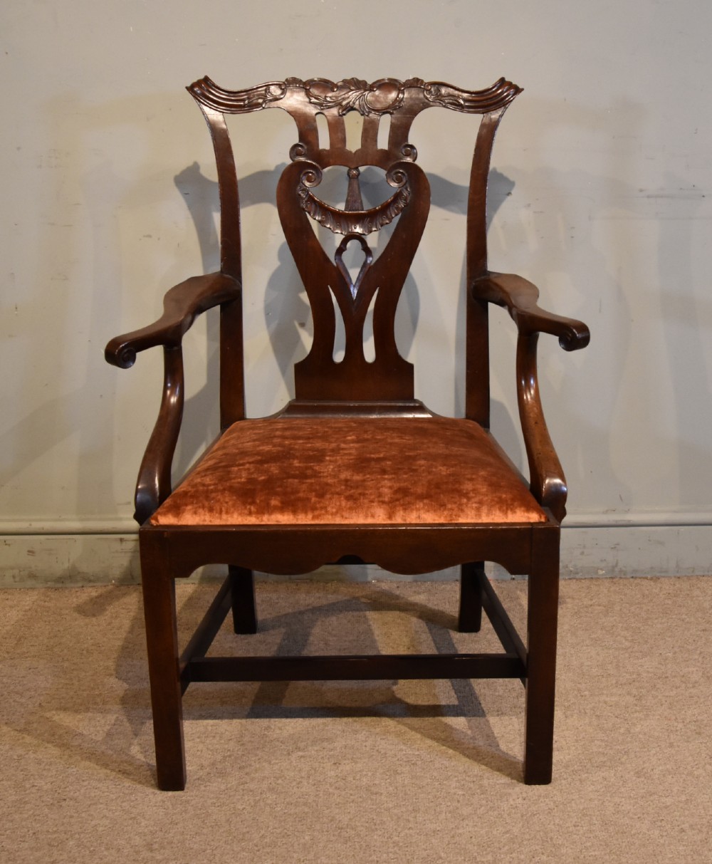 A pair of 18th-century mahogany Irish Chippendale armchairs featuring hand-carved pierced splats, curved arms, and rust-coloured velvet seat pads. View IV
