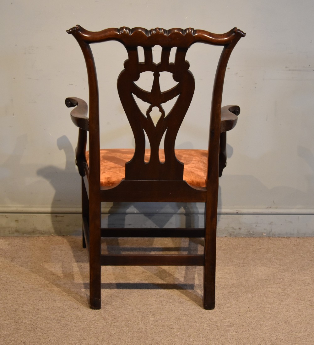 A pair of 18th-century mahogany Irish Chippendale armchairs featuring hand-carved pierced splats, curved arms, and rust-coloured velvet seat pads. View VII