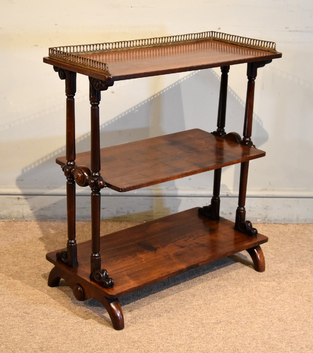 A mid nineteenth-century dark rosewood three-tier whatnot with turned support columns and a pierced brass gallery around the top shelf. View III