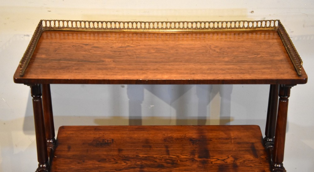 A mid nineteenth-century dark rosewood three-tier whatnot with turned support columns and a pierced brass gallery around the top shelf. View VI