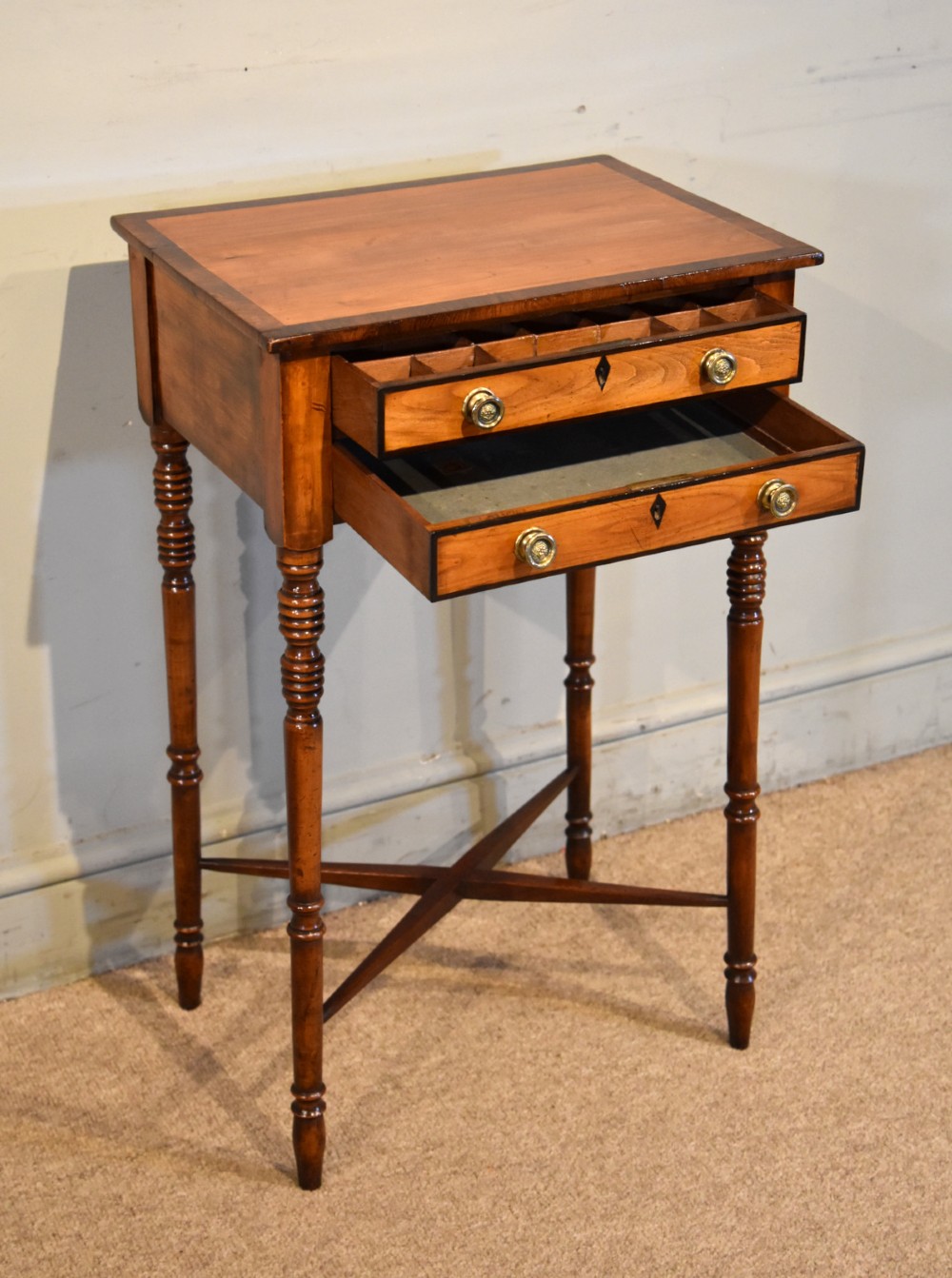A Regency fruitwood side table featuring two small drawers with round brass knobs, rosewood cross-banding, turned legs, and an X-frame stretcher. View III