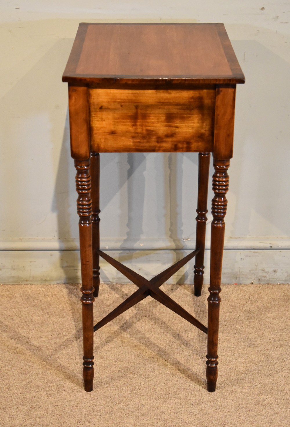 A Regency fruitwood side table featuring two small drawers with round brass knobs, rosewood cross-banding, turned legs, and an X-frame stretcher. View IV