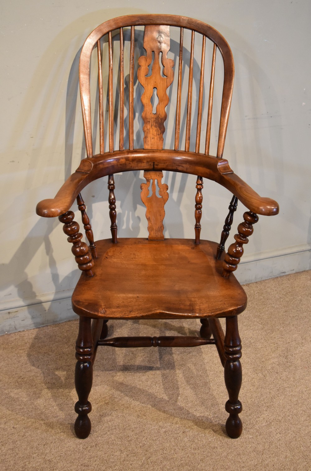 A 19th-century hoop-back Windsor armchair featuring turned wood spindles, a central pierced splat, a contoured saddle seat, and turned legs with an H-stretcher. View II