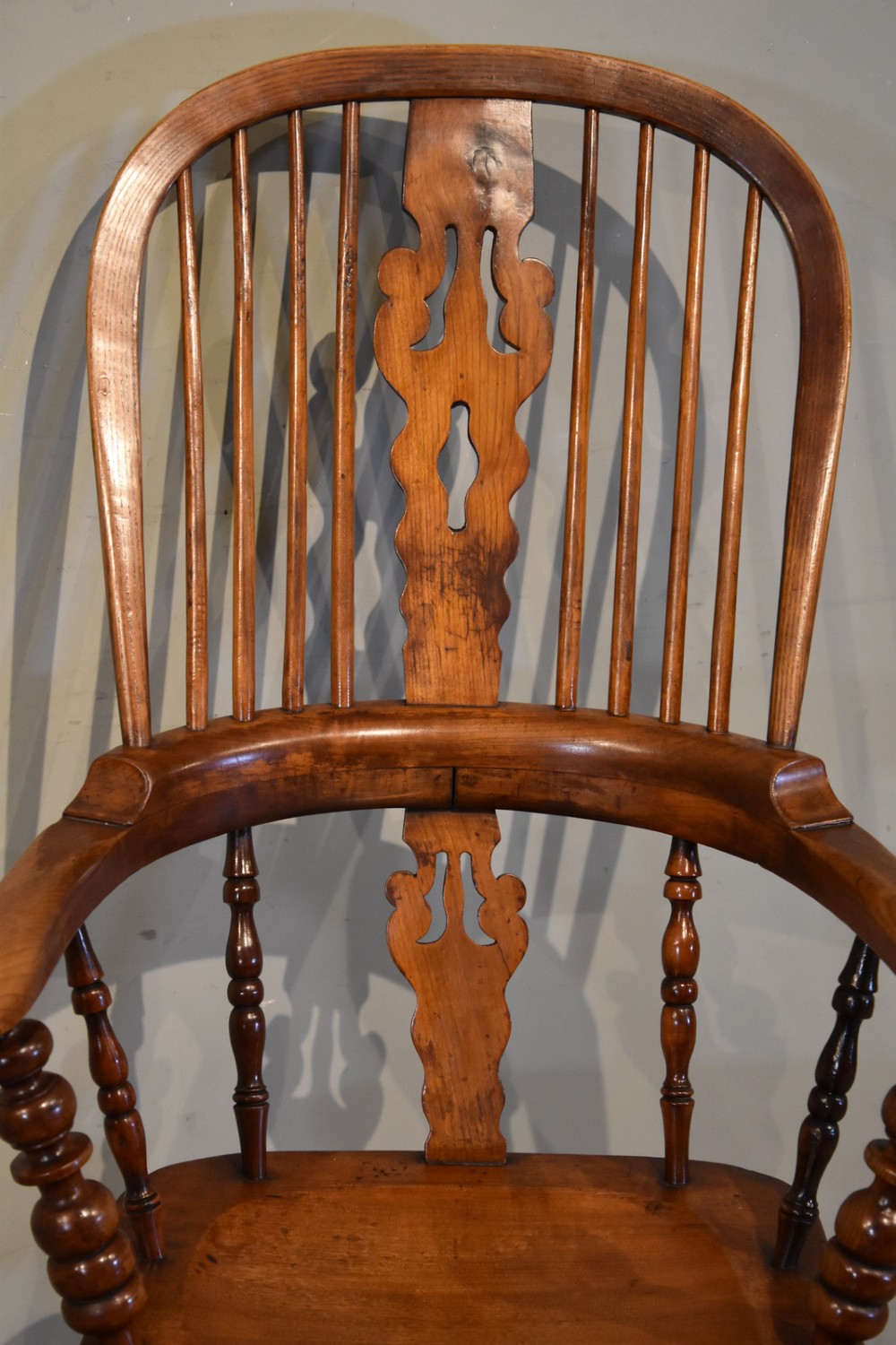 A 19th-century hoop-back Windsor armchair featuring turned wood spindles, a central pierced splat, a contoured saddle seat, and turned legs with an H-stretcher. View III