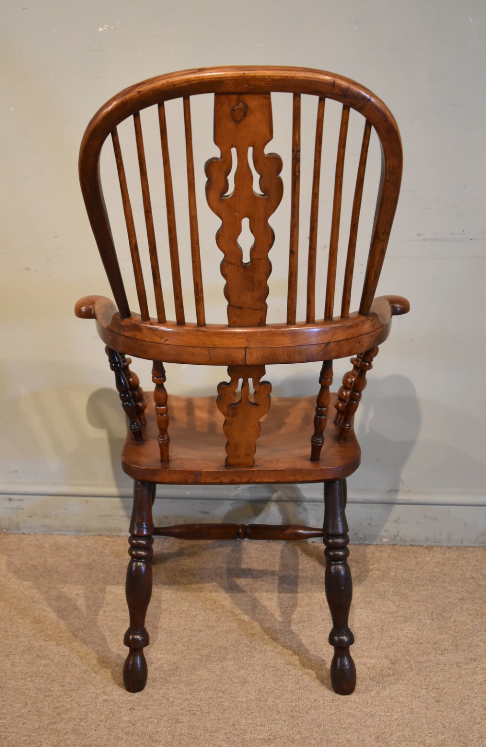 A 19th-century hoop-back Windsor armchair featuring turned wood spindles, a central pierced splat, a contoured saddle seat, and turned legs with an H-stretcher. View VI