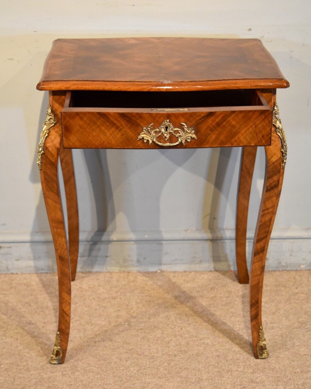 A 19th-century French walnut work table featuring curved cabriole legs, brass knee and foot mounts, a single front drawer with an ornate handle, and matched wood veneer. View II