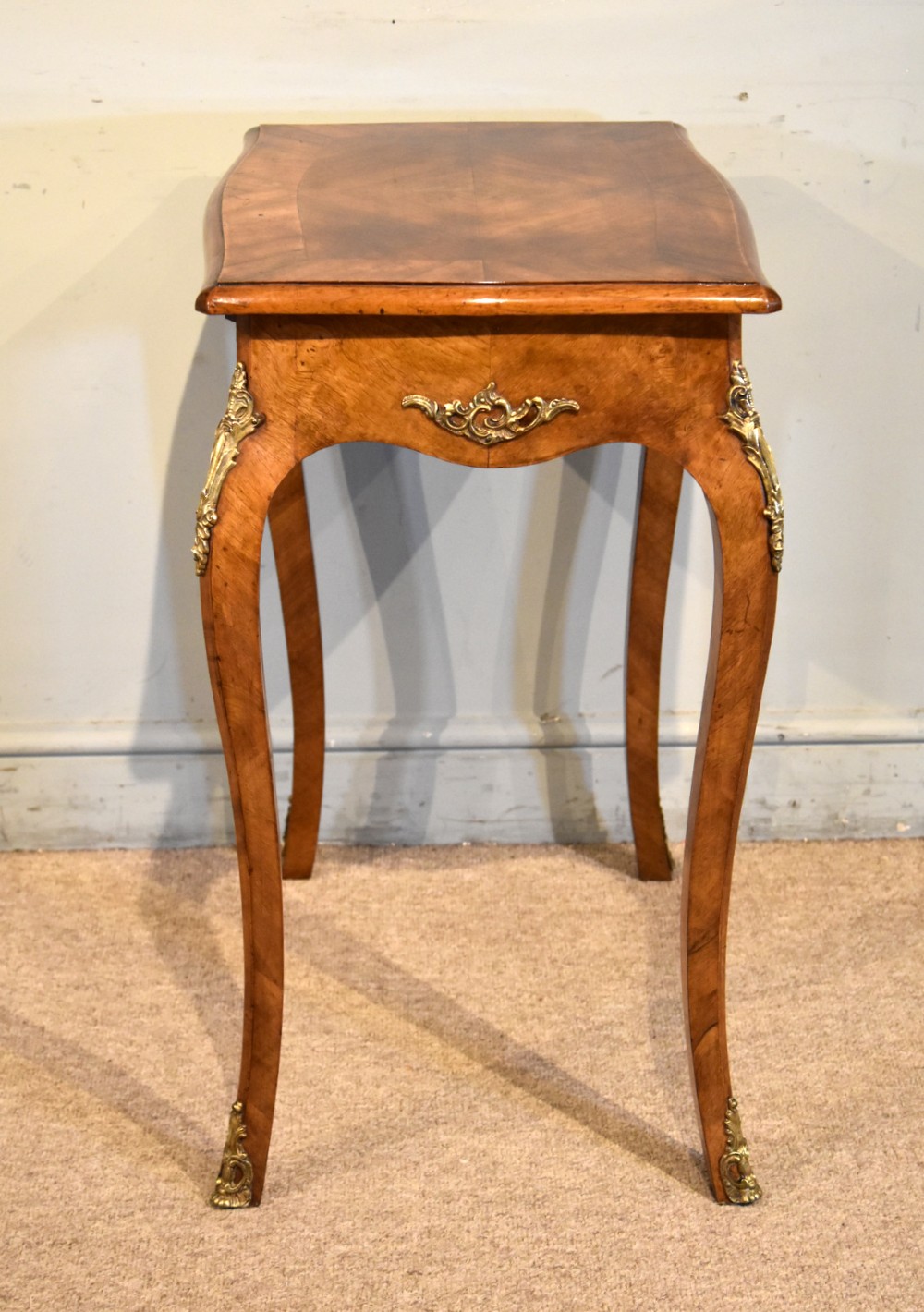 A 19th-century French walnut work table featuring curved cabriole legs, brass knee and foot mounts, a single front drawer with an ornate handle, and matched wood veneer. View IV