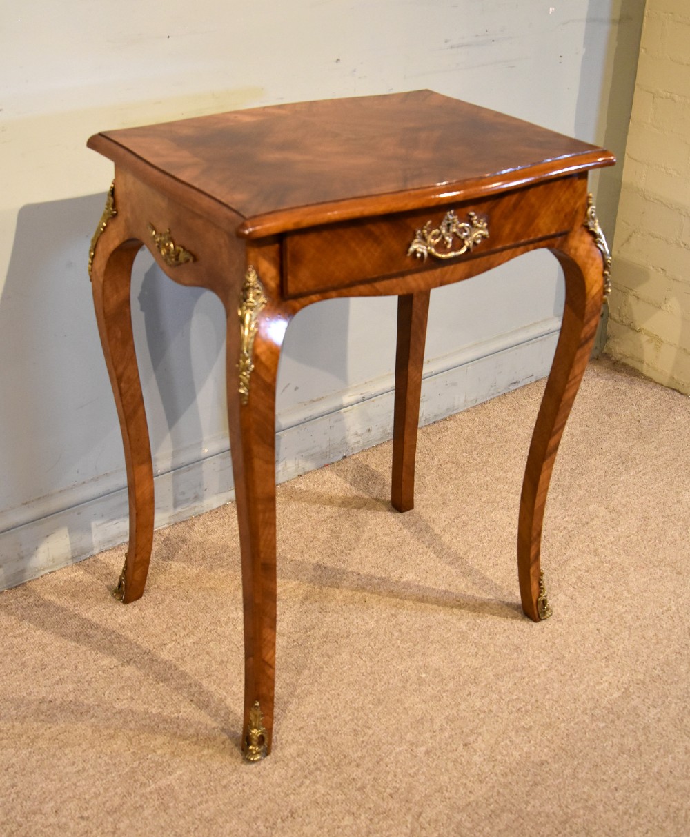 A 19th-century French walnut work table featuring curved cabriole legs, brass knee and foot mounts, a single front drawer with an ornate handle, and matched wood veneer. View VII