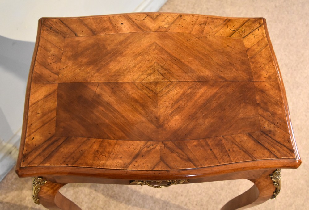 A 19th-century French walnut work table featuring curved cabriole legs, brass knee and foot mounts, a single front drawer with an ornate handle, and matched wood veneer. View VIII