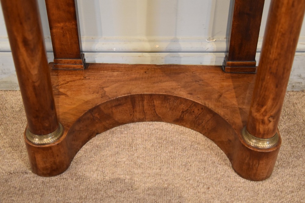 A French Empire flame mahogany console table featuring a grey speckled marble top, a single frieze drawer, and cylindrical column front legs on a shaped base. View V