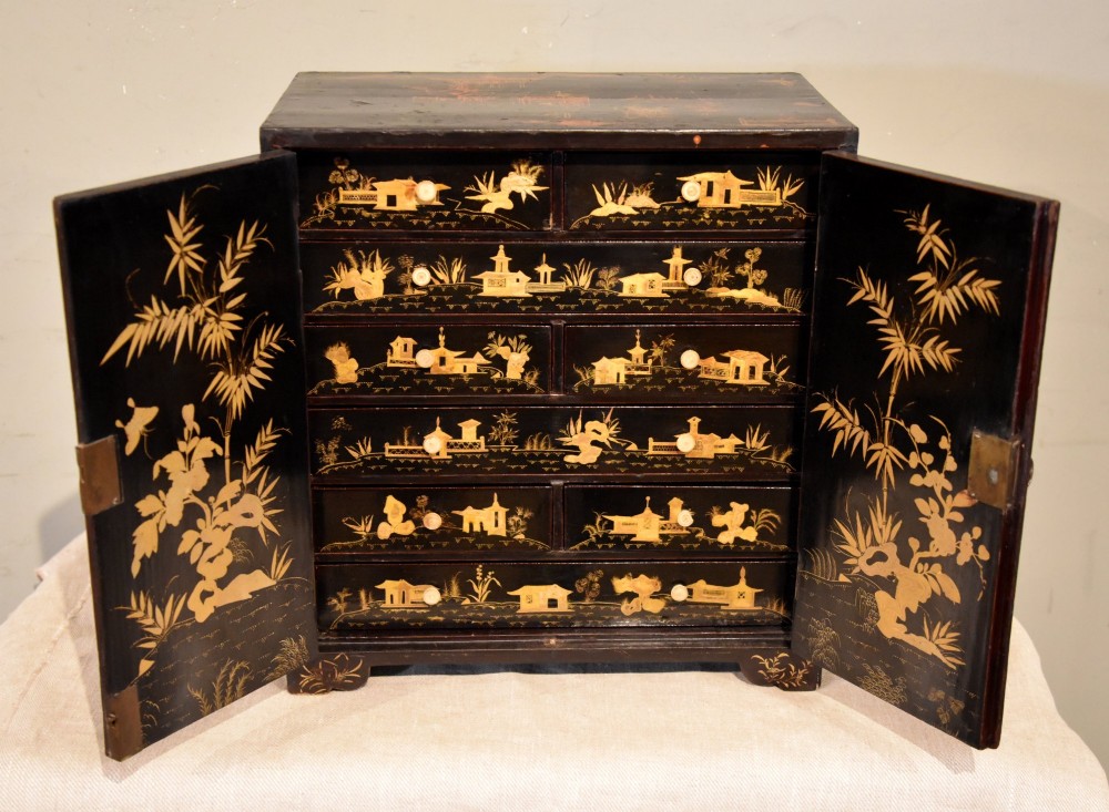 A rectangular black lacquer table cabinet decorated with detailed gold chinoiserie depictions of pagodas, figures, and foliage. View III