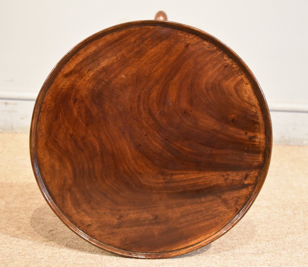 A George III mahogany tripod table featuring a circular dish top supported on a turned baluster column with three splayed legs. View IV