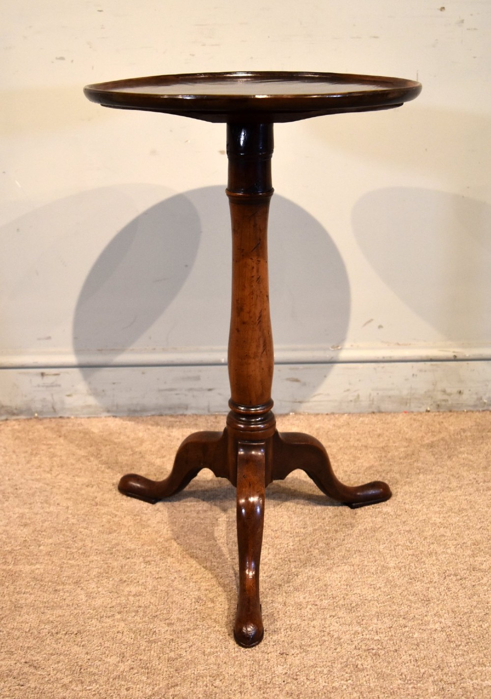 A George III mahogany tripod table featuring a circular dish top supported on a turned baluster column with three splayed legs. View V