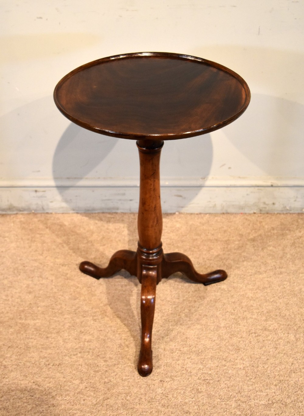 A George III mahogany tripod table featuring a circular dish top supported on a turned baluster column with three splayed legs. View VI