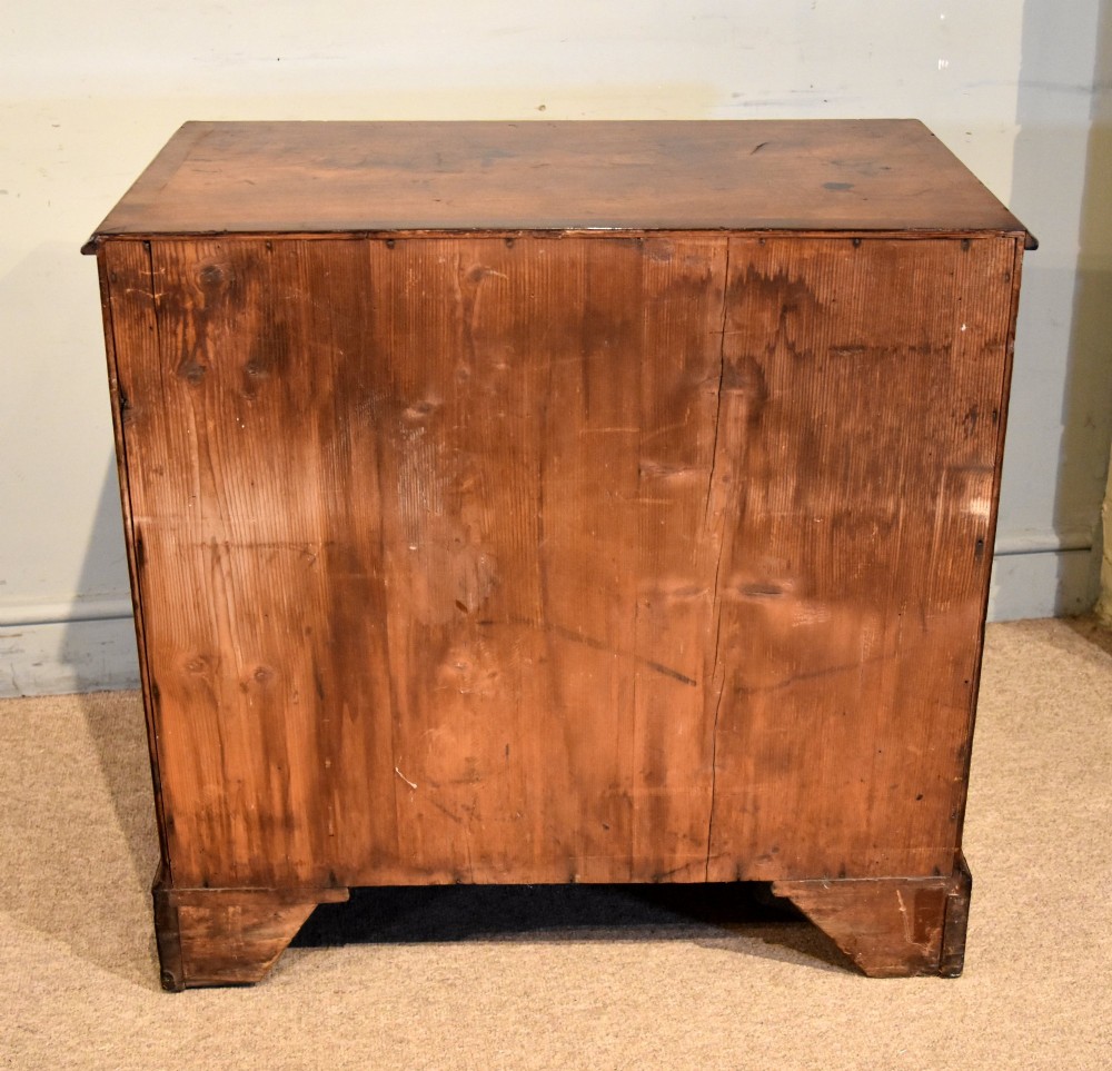 An 18th-century Georgian mahogany chest of drawers featuring two short over three long graduated drawers, brass swan-neck handles, keyhole escutcheons, and bracket feet. View IX