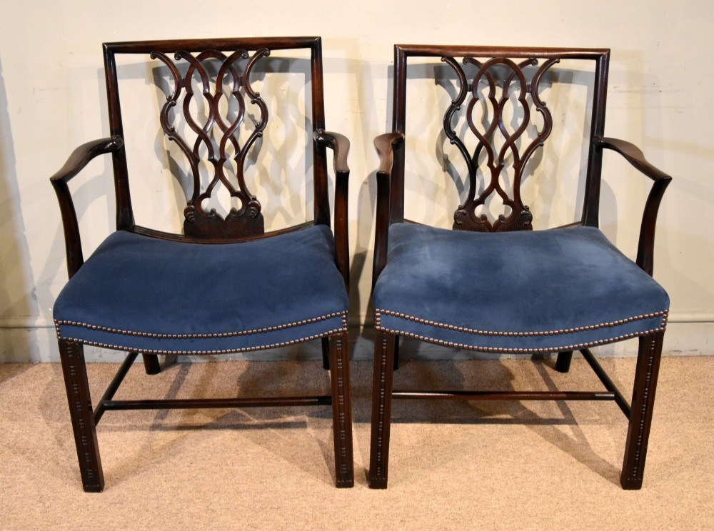A matched pair of dark mahogany Chippendale style armchairs with intricate pierced back splats and blue velvet upholstered seats with brass stud detailing. View II