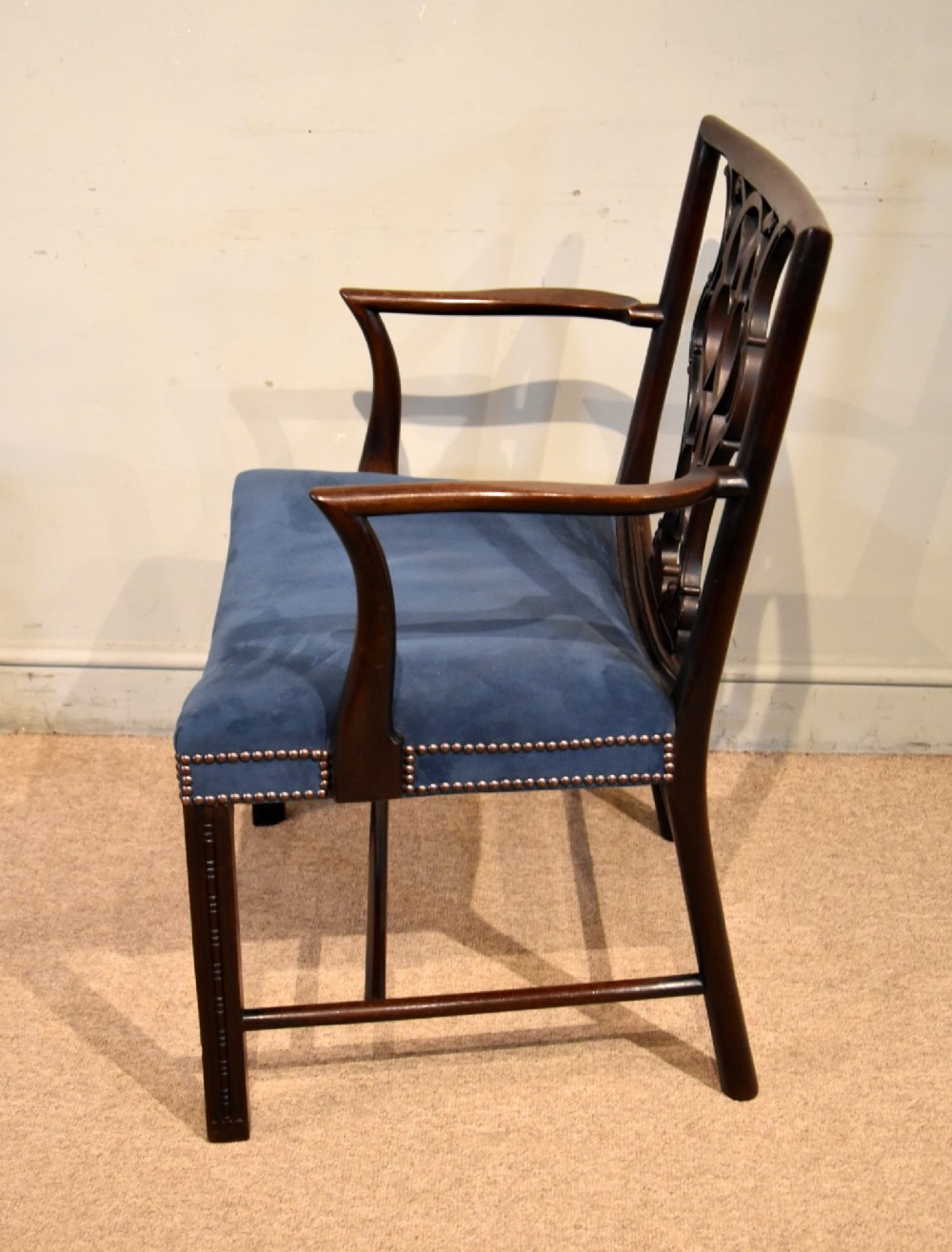 A matched pair of dark mahogany Chippendale style armchairs with intricate pierced back splats and blue velvet upholstered seats with brass stud detailing. View IV