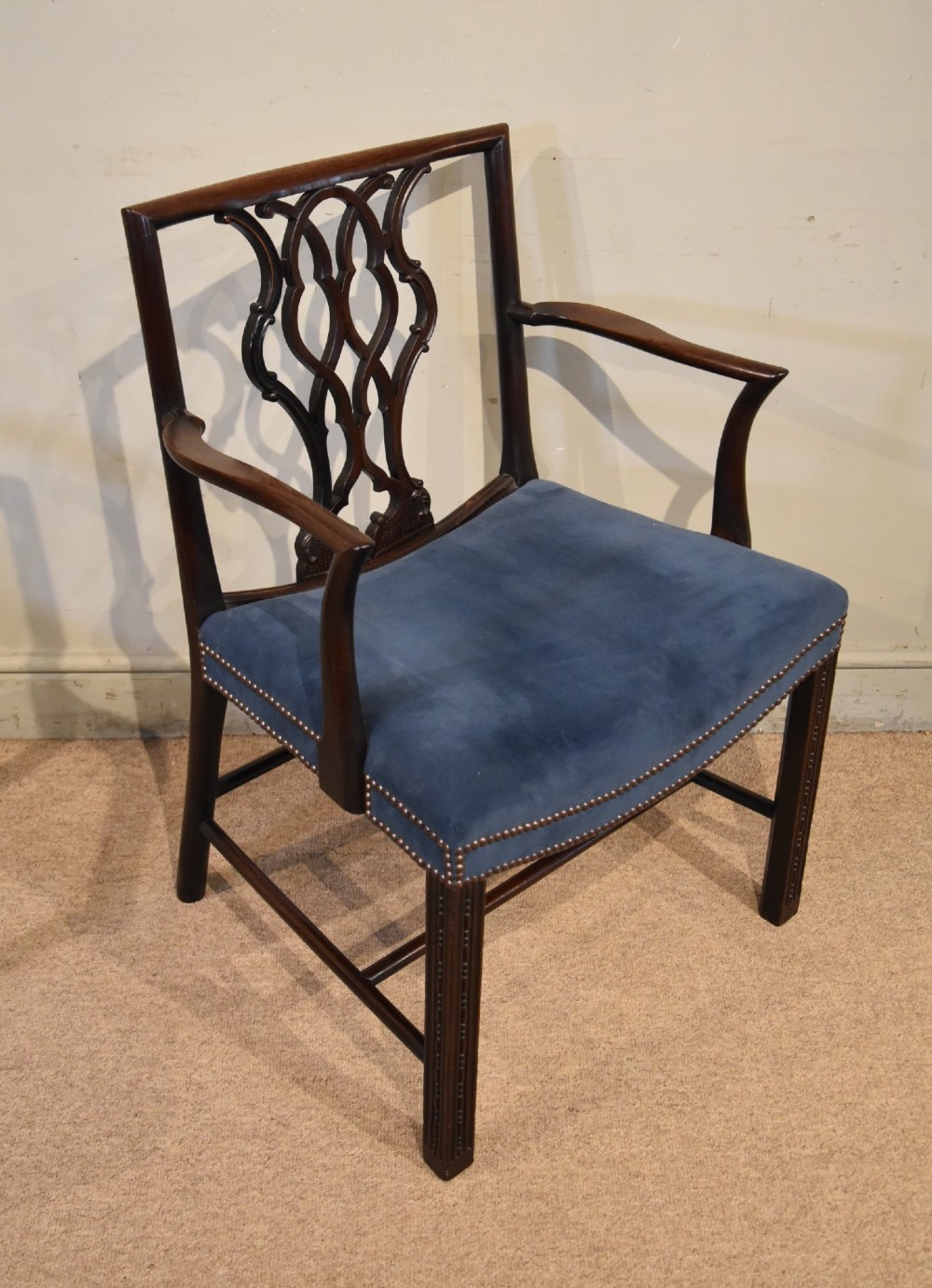 A matched pair of dark mahogany Chippendale style armchairs with intricate pierced back splats and blue velvet upholstered seats with brass stud detailing. View VI