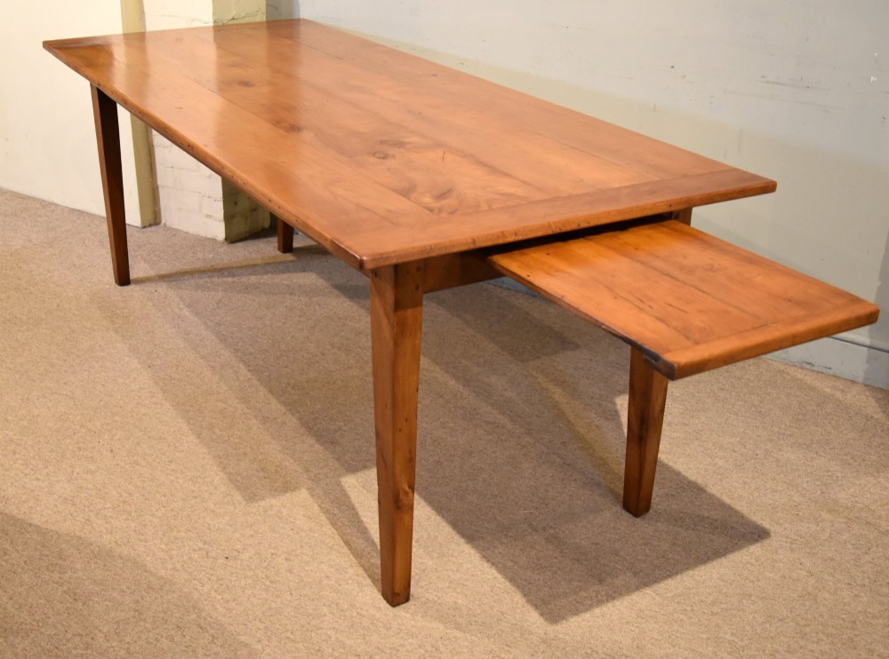 A nineteenth-century French cherry wood farmhouse table featuring a rectangular planked top, breadboard ends, a simple apron, and square tapered legs. View VII