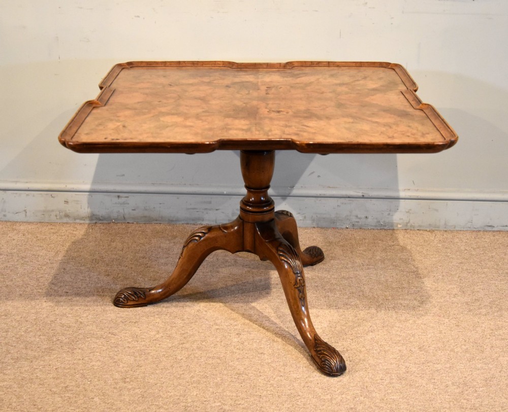 A Victorian tilt-top supper table made from burr walnut featuring a shaped top and a carved tripod pedestal base. View III