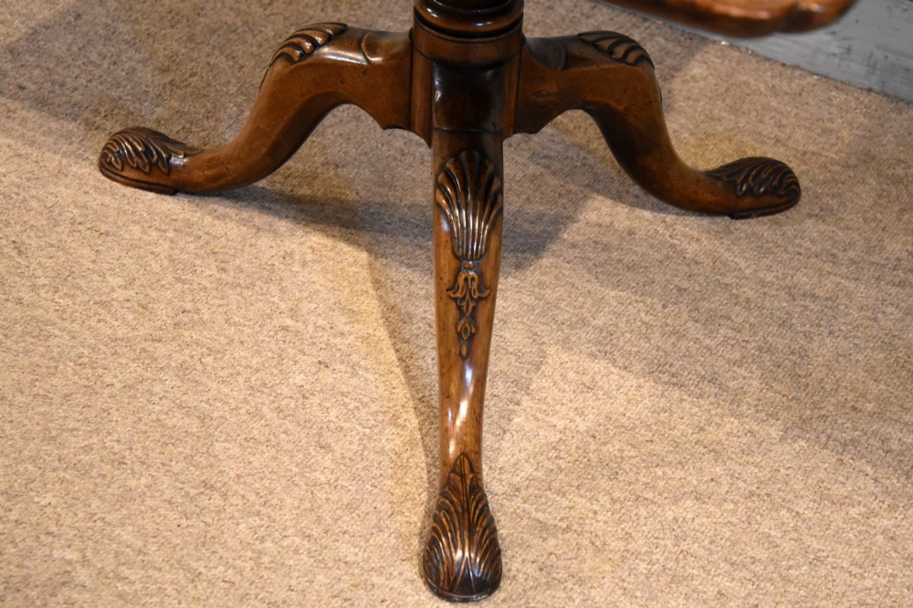 A Victorian tilt-top supper table made from burr walnut featuring a shaped top and a carved tripod pedestal base. View IV