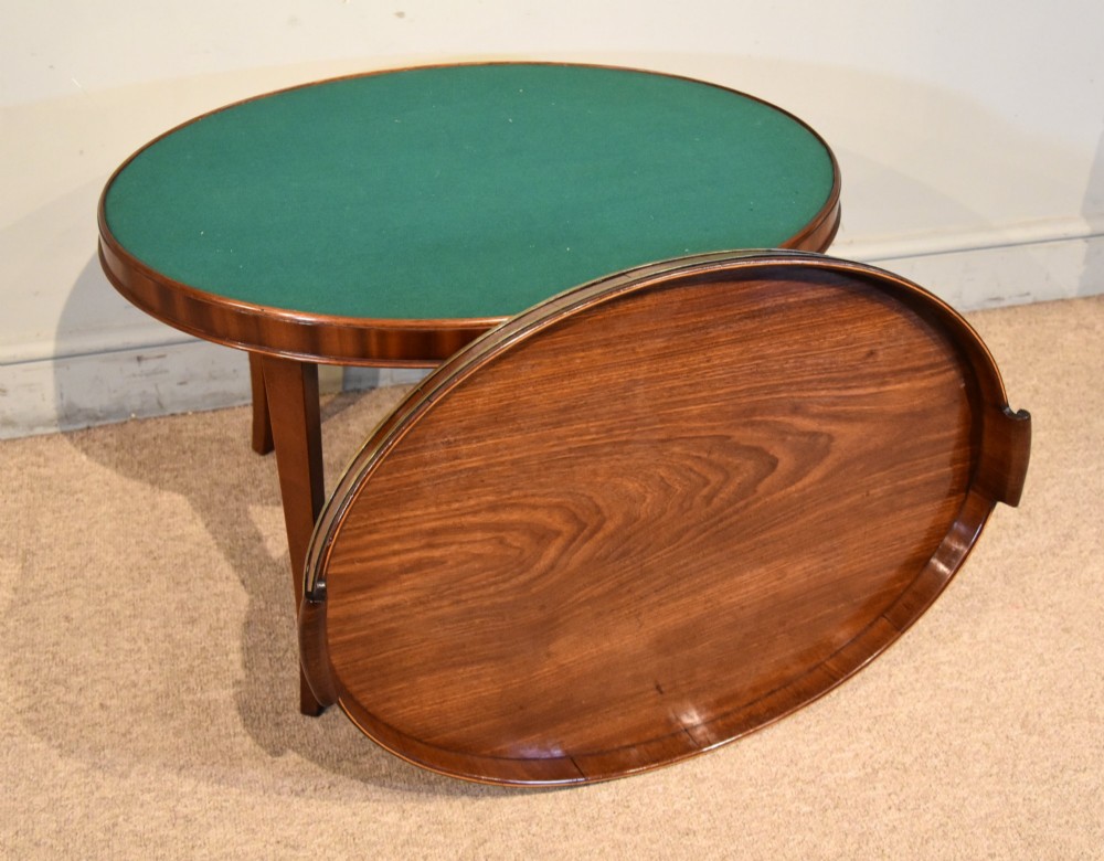 A late eighteenth-century oval mahogany tray table featuring a raised gallery edge, side cut-out handles, brass rim detailing, and tapered curved legs. View II