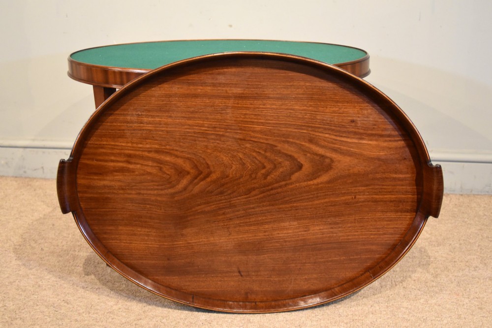 A late eighteenth-century oval mahogany tray table featuring a raised gallery edge, side cut-out handles, brass rim detailing, and tapered curved legs. View III