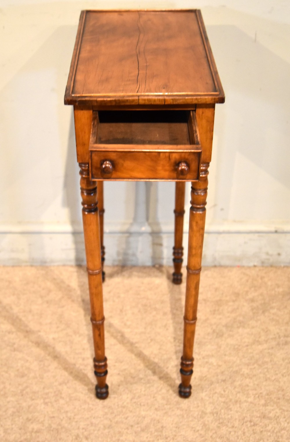 A tall, slender Regency West Indian wooden side table featuring bamboo-turned legs, a raised gallery top, and a small single end drawer. View V