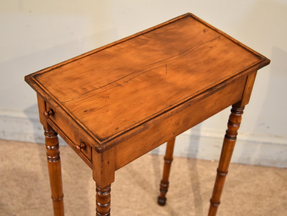 A tall, slender Regency West Indian wooden side table featuring bamboo-turned legs, a raised gallery top, and a small single end drawer. View VI