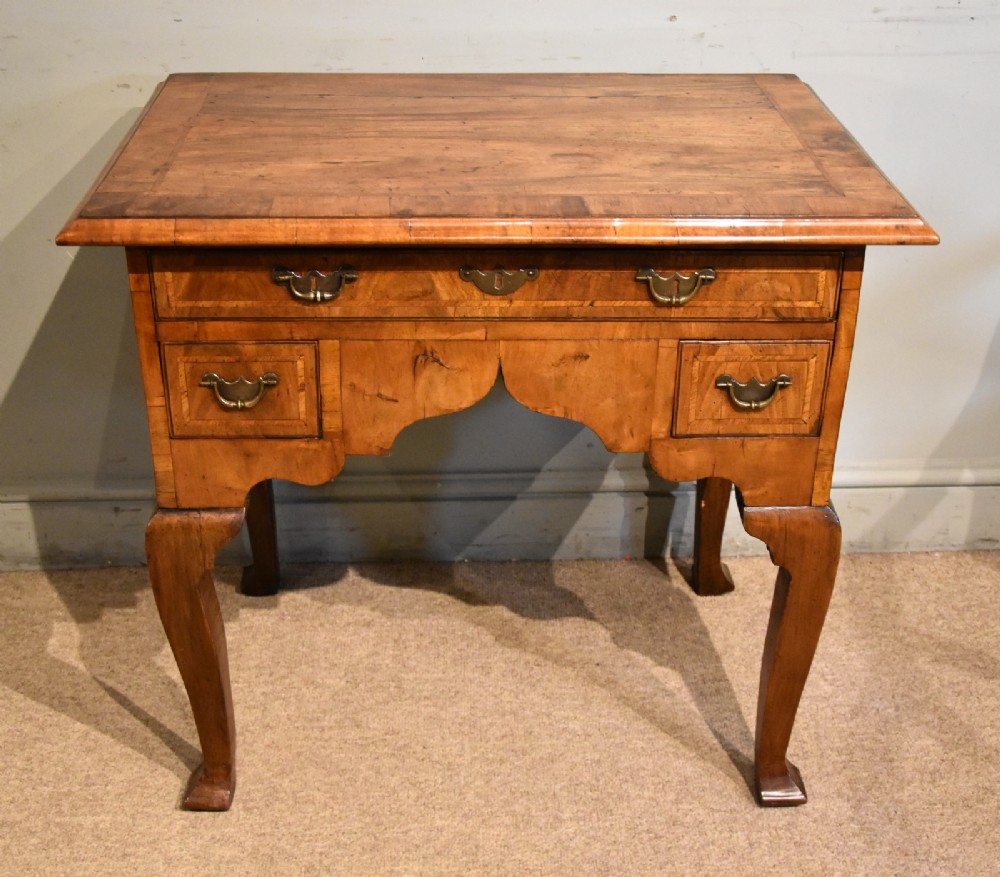 An 18th-century walnut lowboy featuring a crossbanded top, three drawers with brass drop handles, a shaped apron, and four cabriole legs. View II