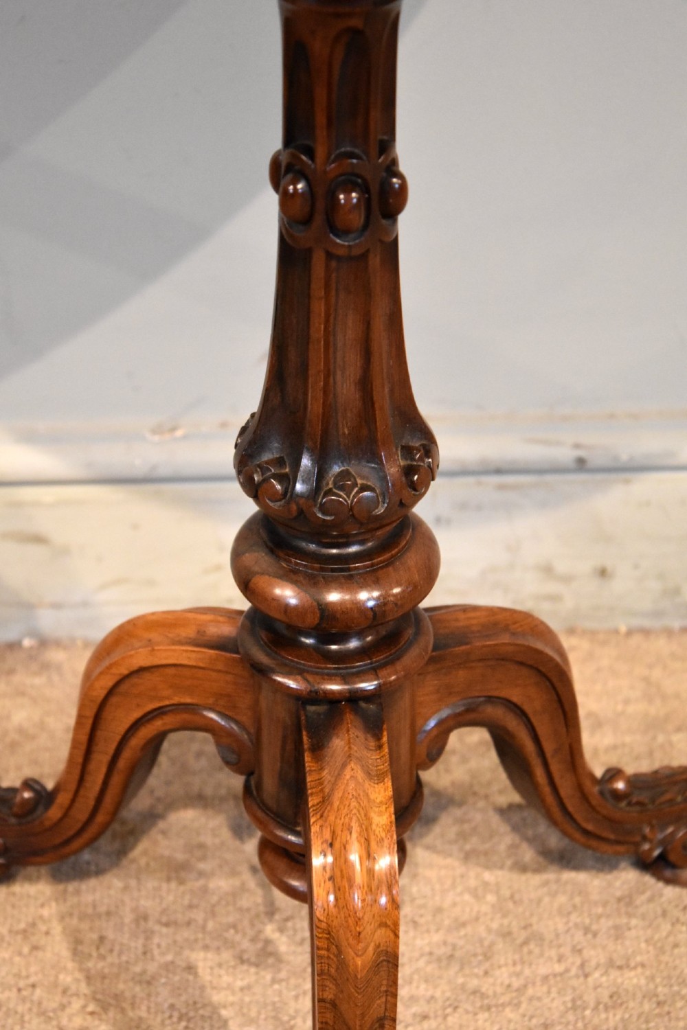 A William IV rosewood tripod games table featuring a circular top inlaid with a chess board above a carved turned stem and scroll feet. View IV