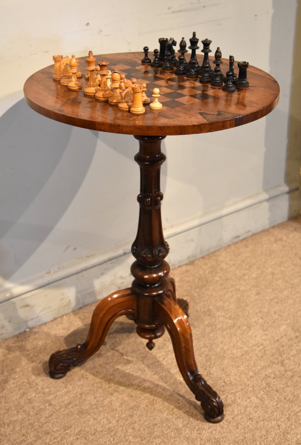 A William IV rosewood tripod games table featuring a circular top inlaid with a chess board above a carved turned stem and scroll feet. View V