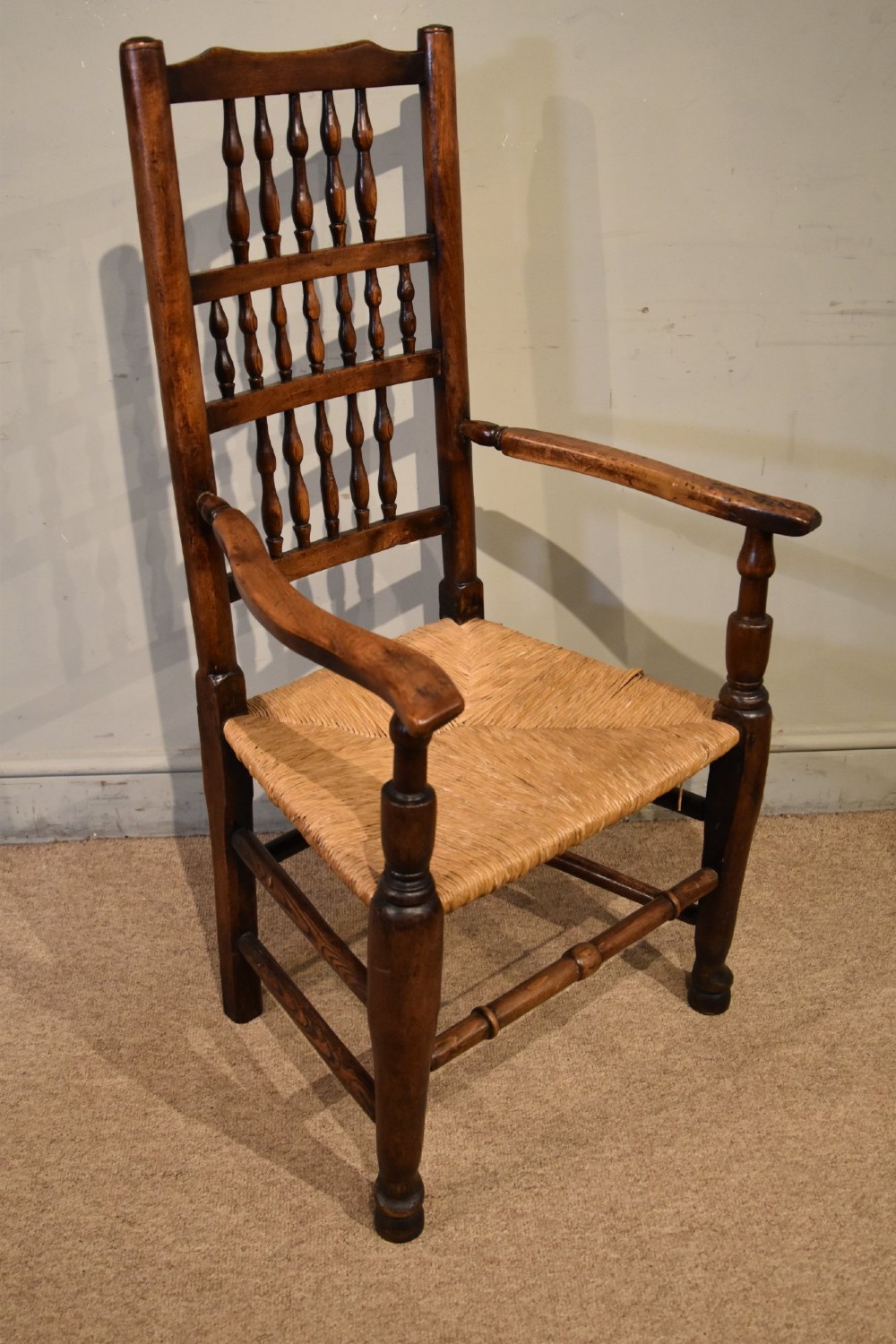 A set of ten brown oak dining chairs featuring double-tier spindle backs, woven rush seats, and turned stretchers. View VIII