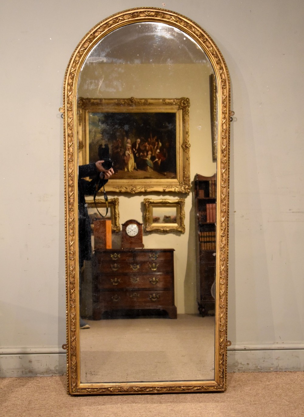 A tall 19th-century full-length mirror featuring an arched gold gilded frame with beaded and foliate moulding. View II